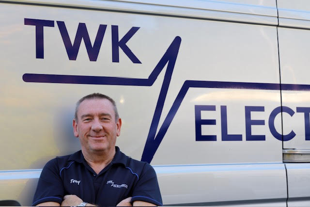 Tony King, founder of TWK Electrical, stood smiling in front of his branded silver van.